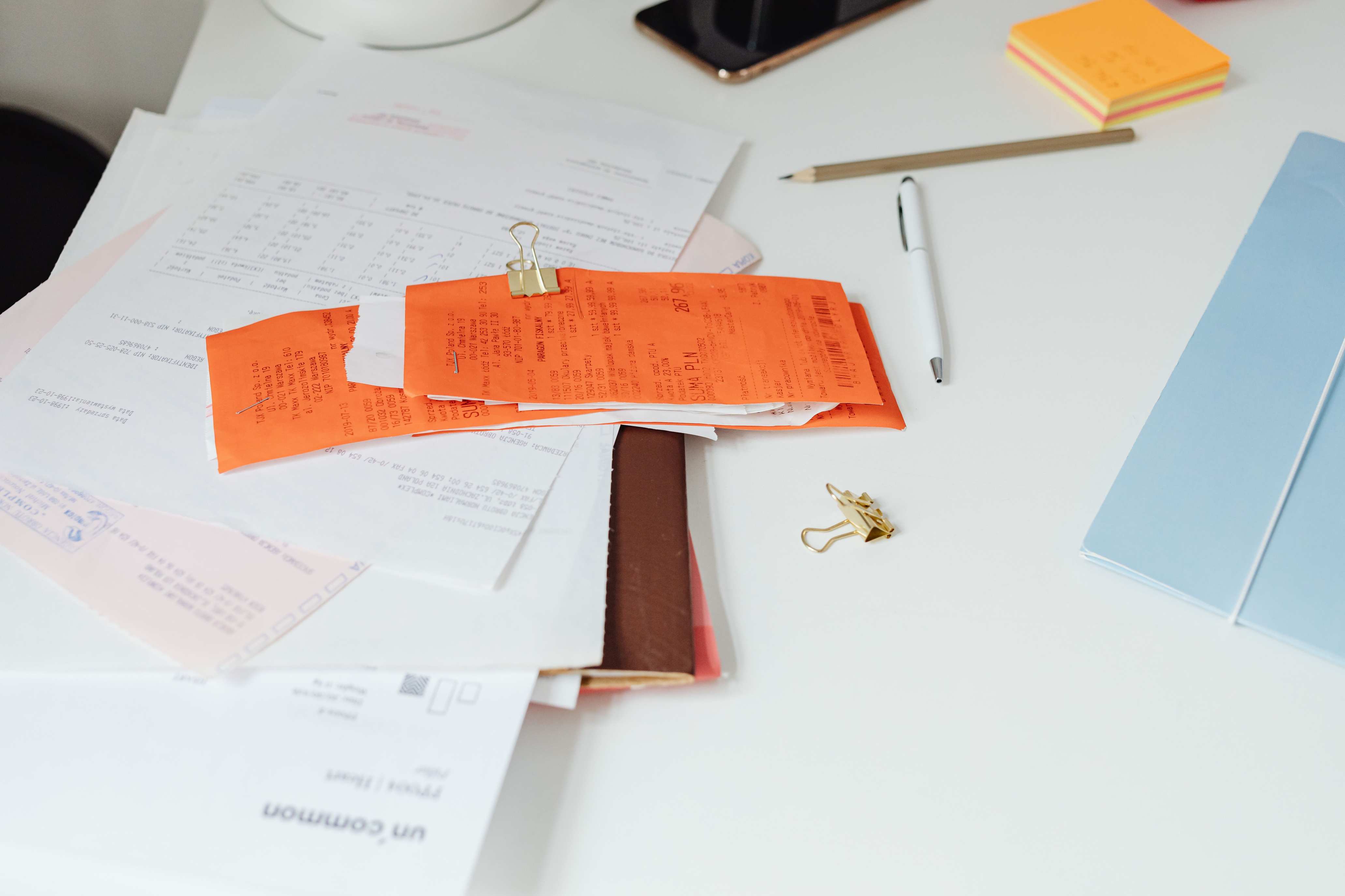 Schreibtisch mit Belegen, Rechnungen, Dokumenten und Bürobedarf für die Geschäftsorganisation
