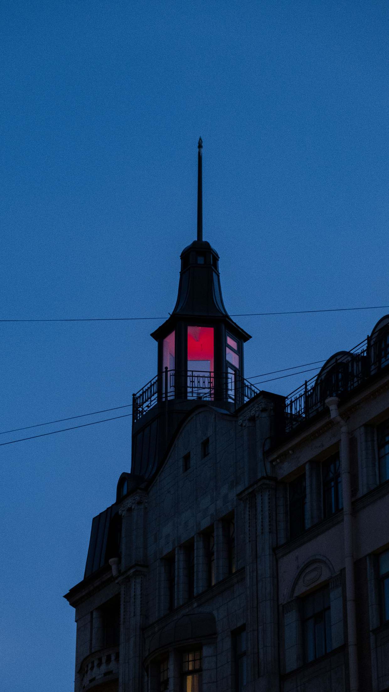 Bürohochhaus mit roter Beleuchtung gegen einen dunklen Abendhimmel